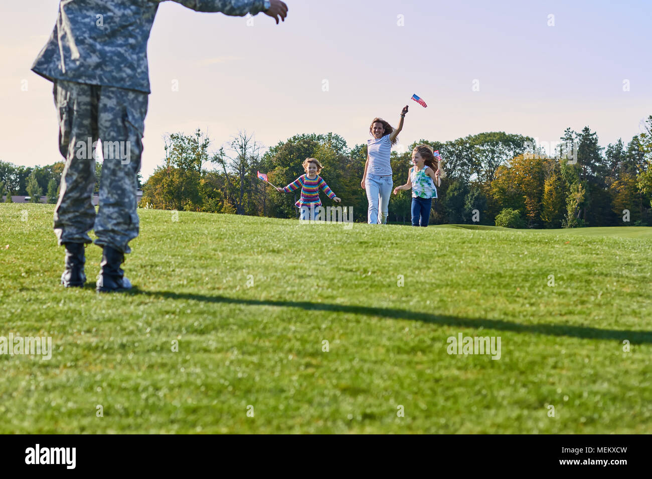 Happy usa family is meeting their father in military camouflage. Stock Photo