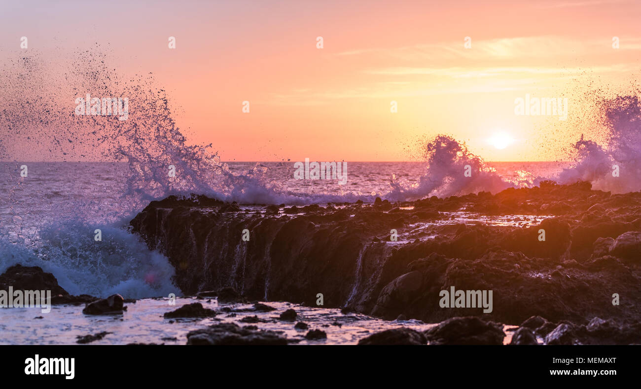 Waves break on pacific coast tide pools during sunset Stock Photo
