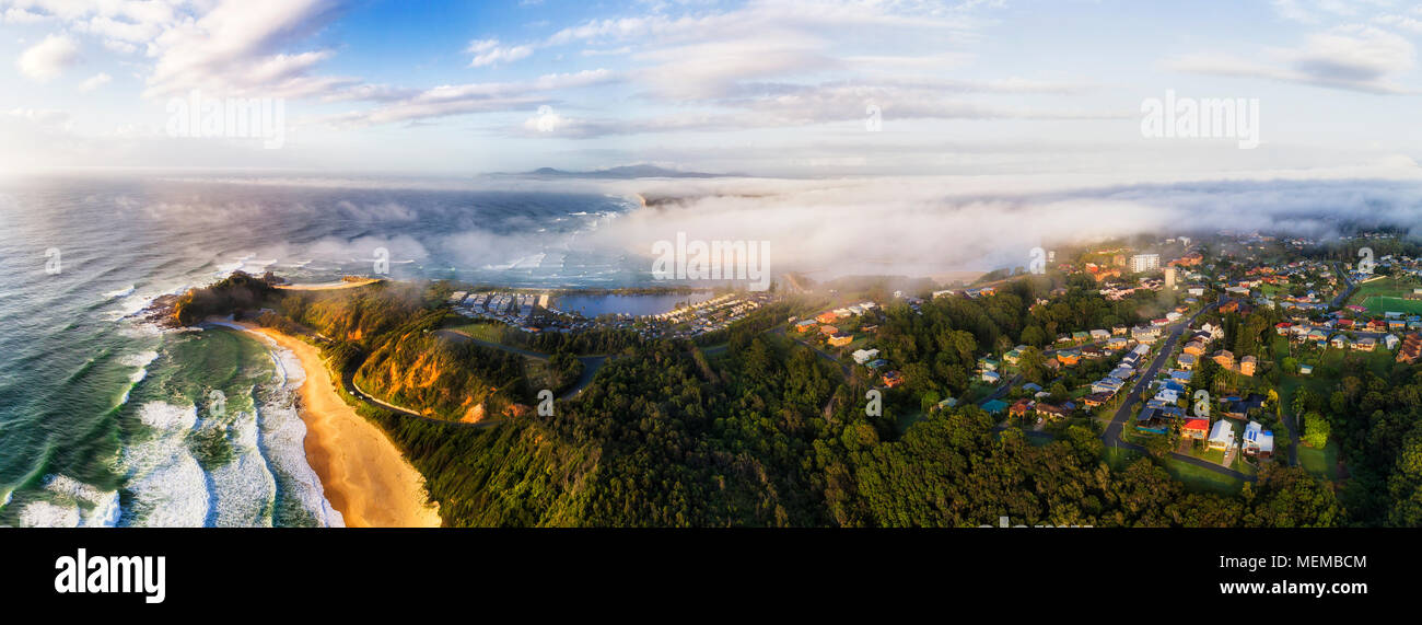 Headland of Nambucca Heads town near Nambucca river mouth and entrance to Pacific ocean on a misty cloudy morning when warm sunlight gets through thic Stock Photo