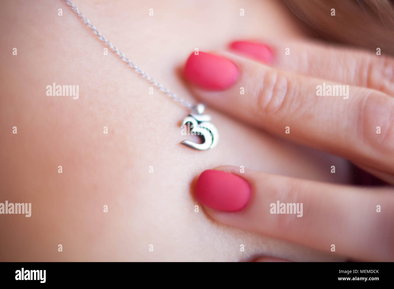 Om symbol medallion around the neck of a woman. Stock Photo
