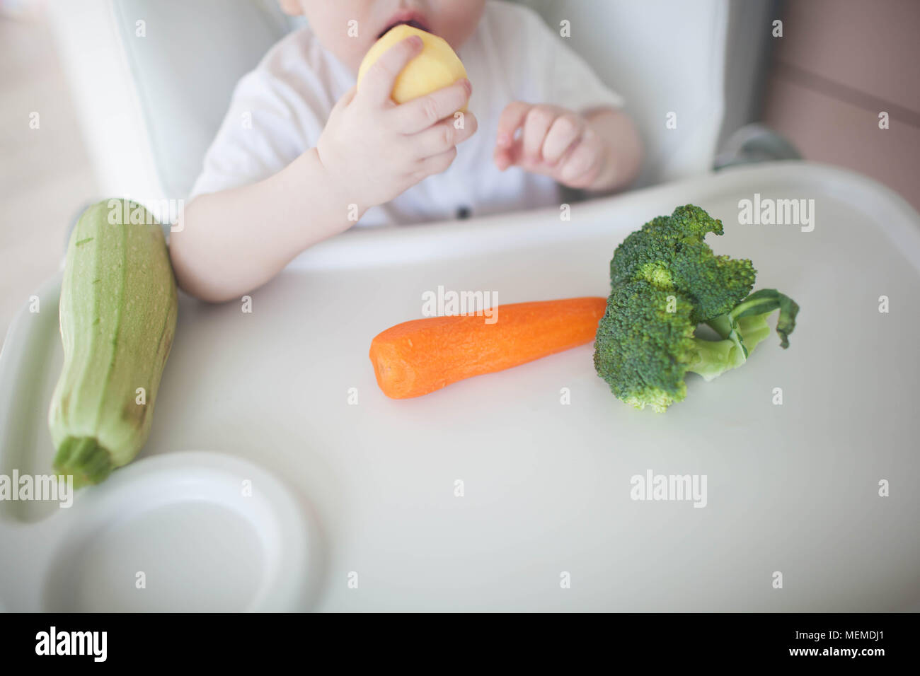 The baby is eating potatoes Stock Photo Alamy