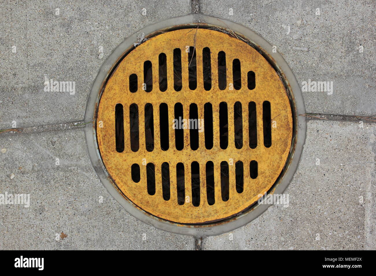 Weathered grate cover for a water drain on a cemetery. Stock Photo