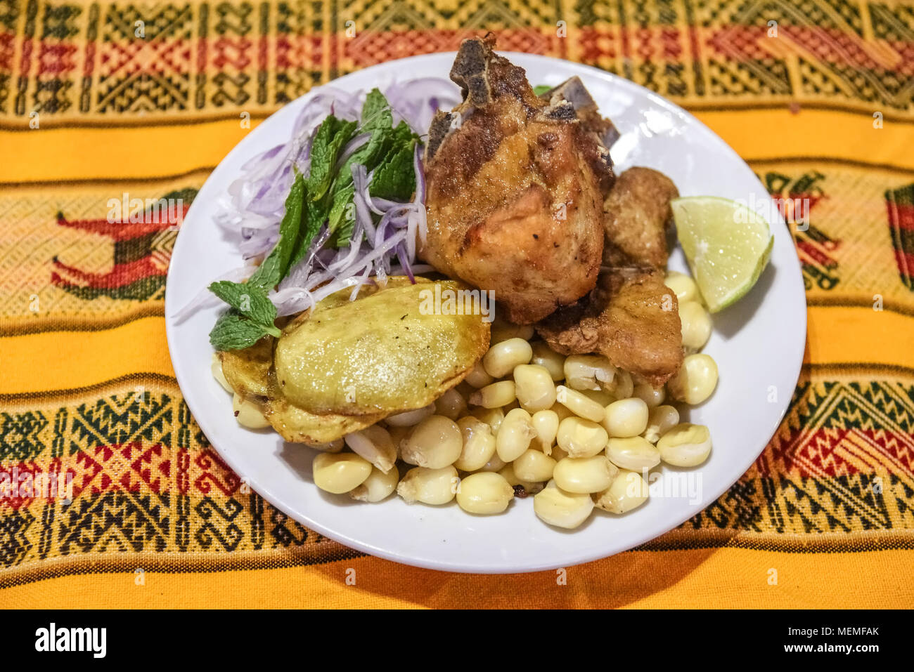 Peruvian dish, pork meat with corn, potatoes and red onion salad. Very popular menu in Peru. Stock Photo