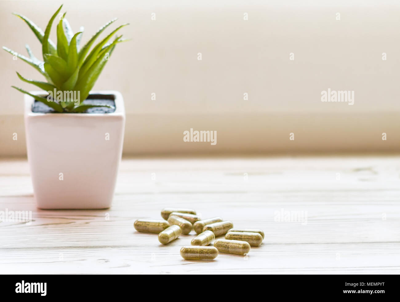 Group of clear CBD Cannabidiol capsules on bright wooden backdrop Stock Photo