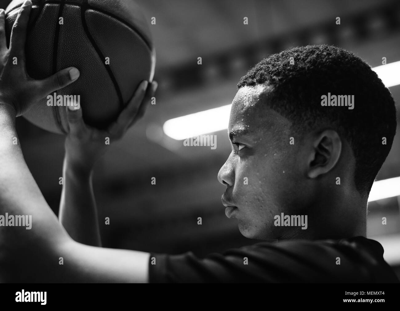 African American teenage boy concentrated on playing basketball Stock Photo