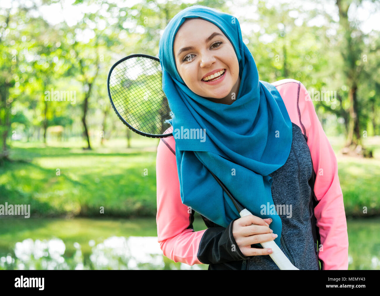 Cheerful muslim woman playing badminton Stock Photo