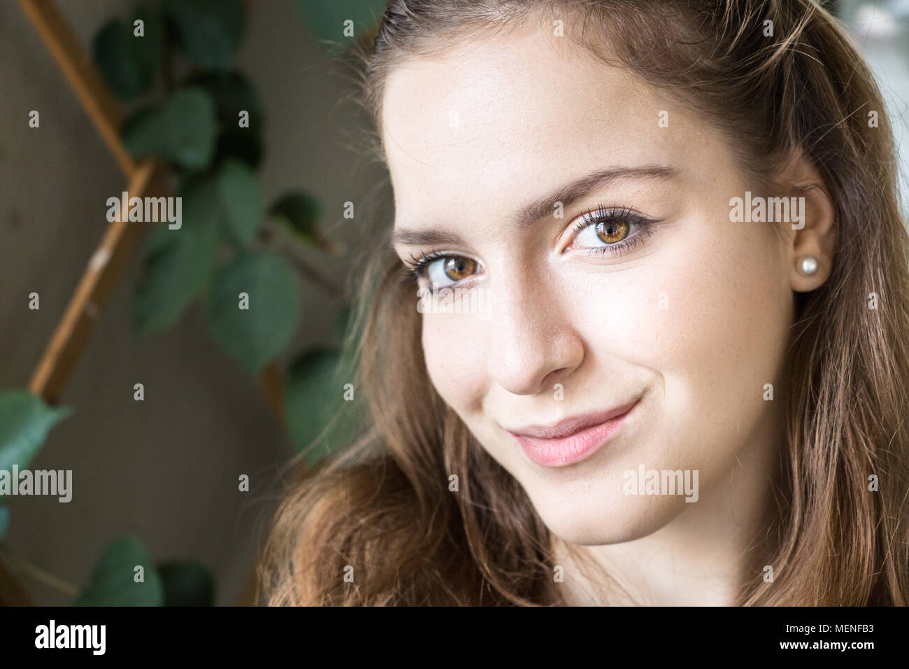 Portrait of a teenager girl, close up, looking at camera at home with sweet expression. Stock Photo