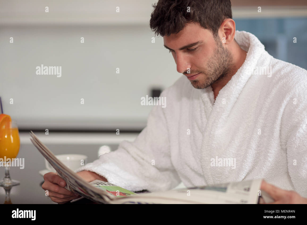 young freelancer in bathrobe working from home using tablet computer Stock Photo