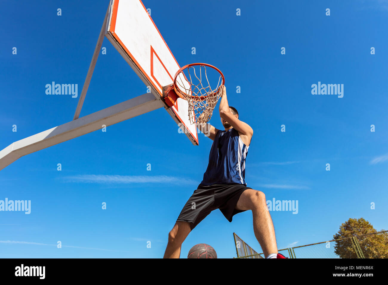 Slam Dunk. Side view of young basketball player making slam dunk Stock ...