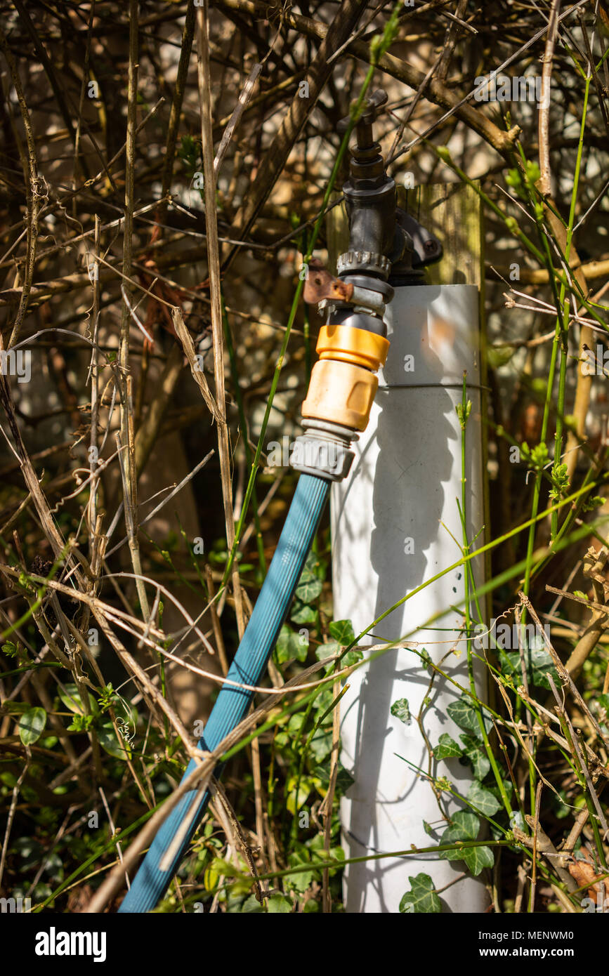 an old hosepipe attached to a tap Stock Photo