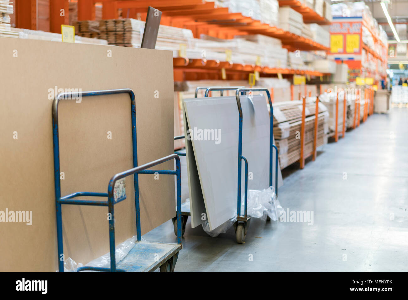 Rows of shelves with boxes and storage carts in modern warehouse Stock
