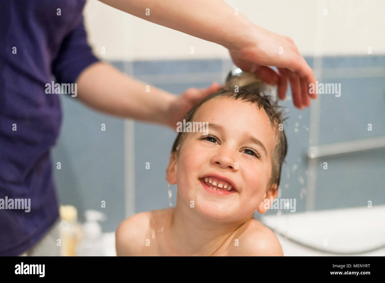 Mother washing shower with baby in bath. Mom's hands washing little boy