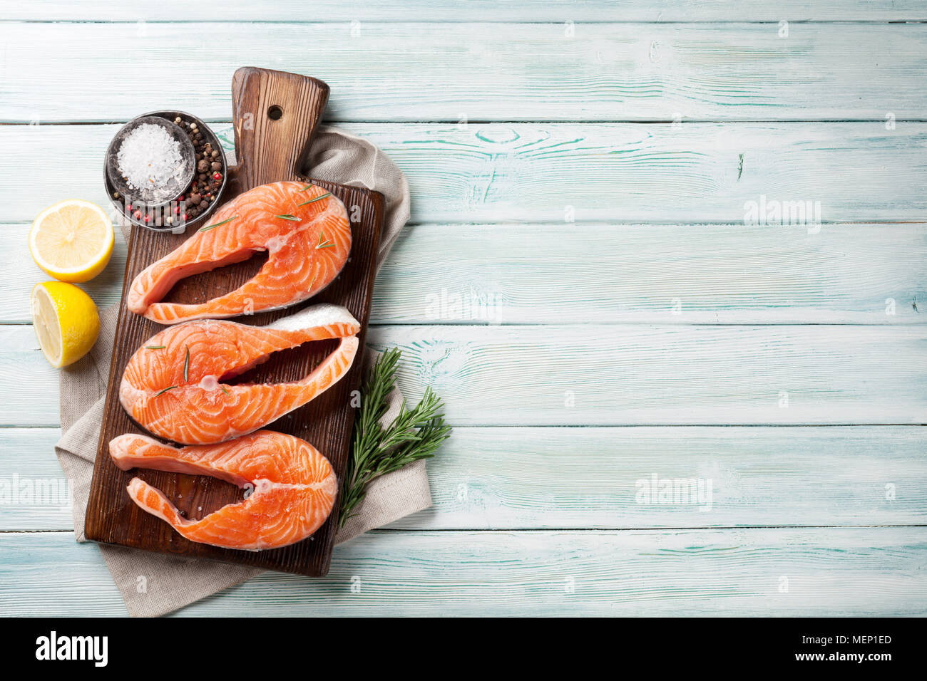 Raw salmon fish steaks with spices cooking on cutting board. Top view ...