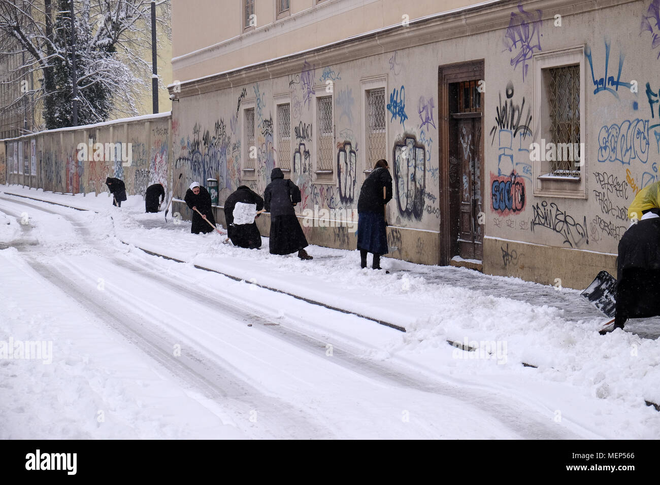 Nuns clean the snow in front of the monastery in Zagreb, Croatia January 03, 2016 Stock Photo