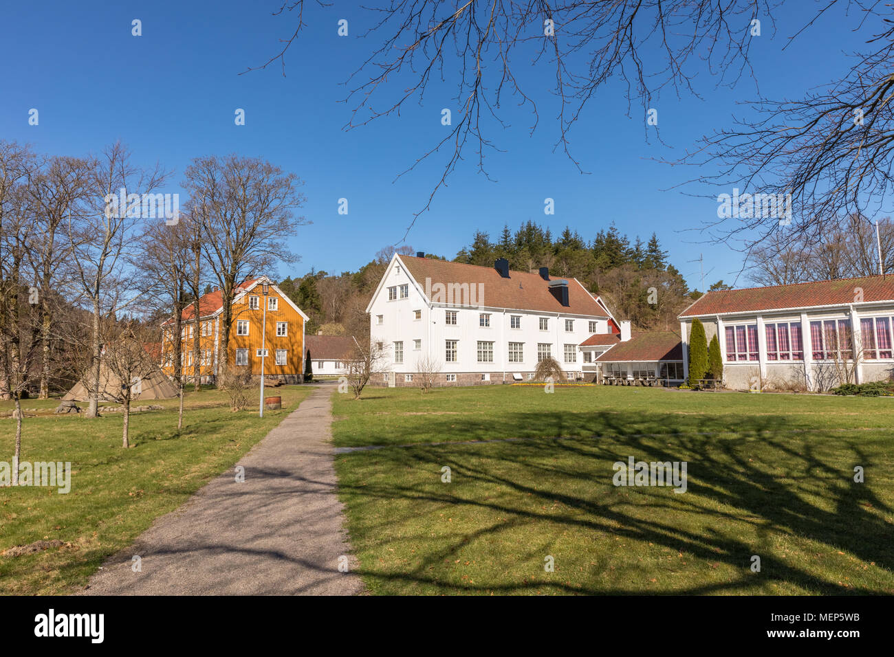 Sogne, Norway - April 21, 2018: Sogne Gamle Prestegard, or Old Sogne Rectory. Vicarage with wooden buildings, Vest-Agder in Norway. Blue sky, green grass. Stock Photo