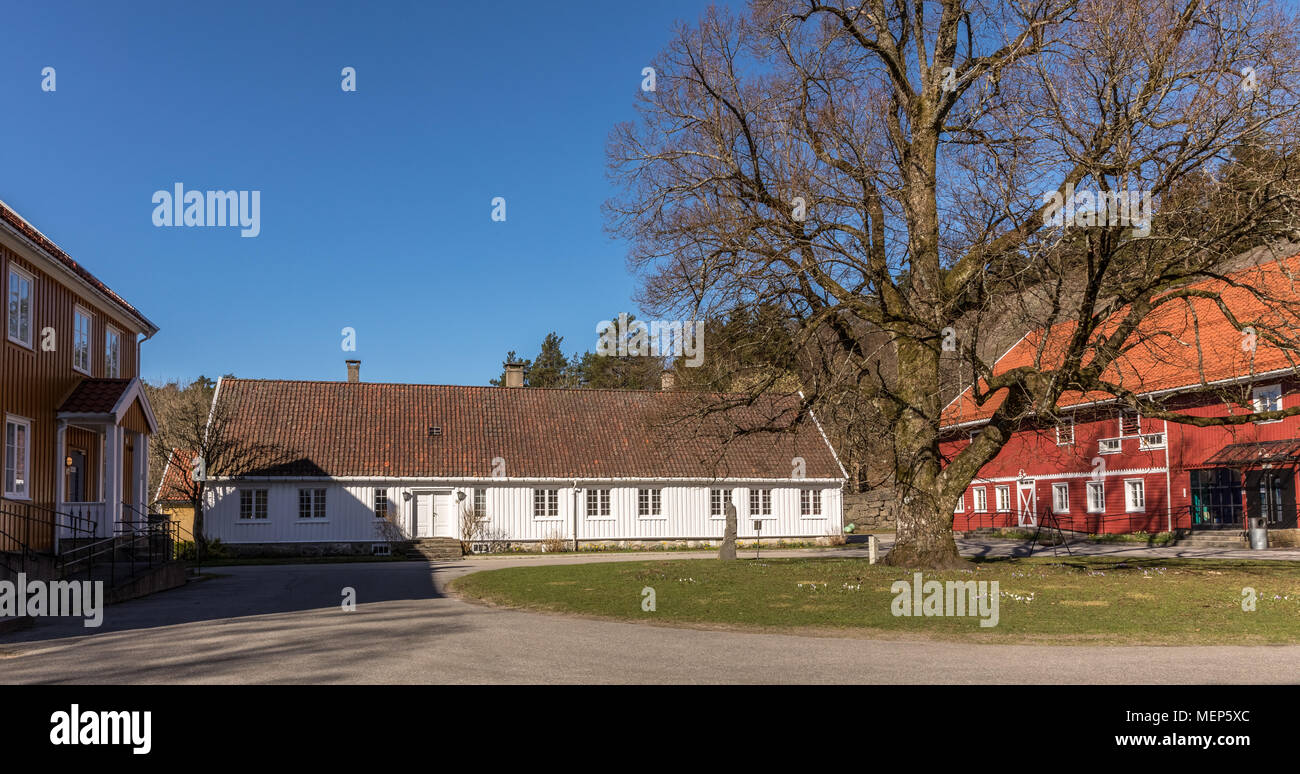 Sogne, Norway - April 21, 2018: Sogne Gamle Prestegard, or Old Sogne Rectory. Vicarage with wooden buildings, Vest-Agder in Norway. Blue sky, green grass. Stock Photo