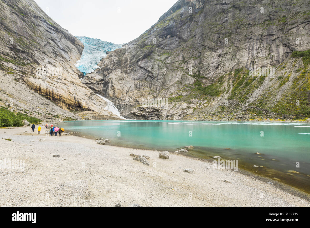 glacier Briksdalsbreen and its lake, Norway, arm of the Jostedal glacier, Oldedalen, Olden at the Nordfjorden, tourists on the shore Stock Photo