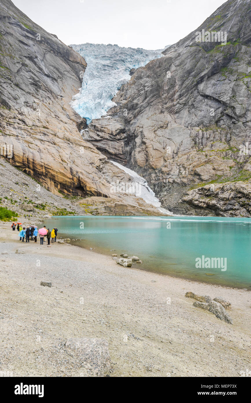 glacier Briksdalsbreen and its lake, Norway, arm of the Jostedal glacier, Oldedalen, Olden at the Nordfjorden, international tourists by rain Stock Photo