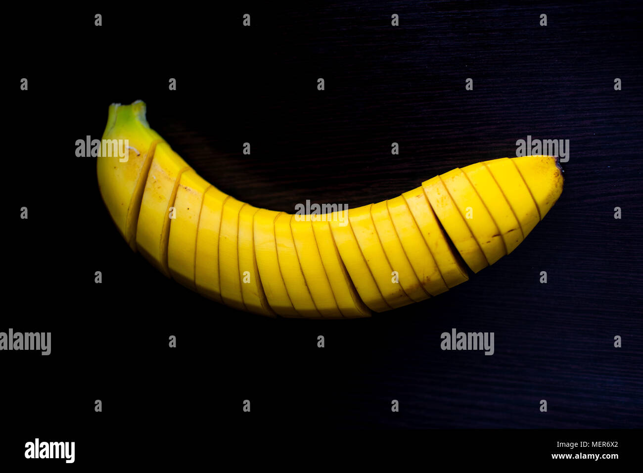 Low key Shot of one banana sliced into pieces Stock Photo