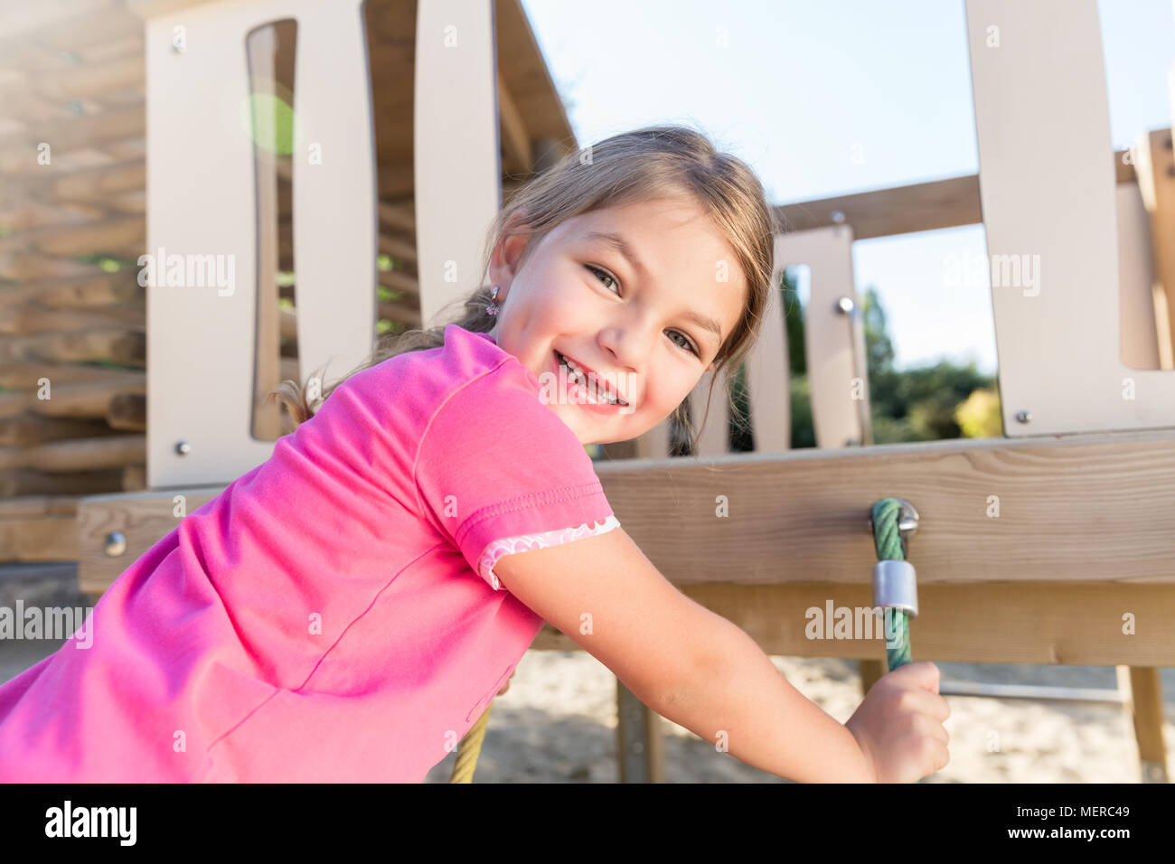 Little girl climbing on adventure playground Stock Photo