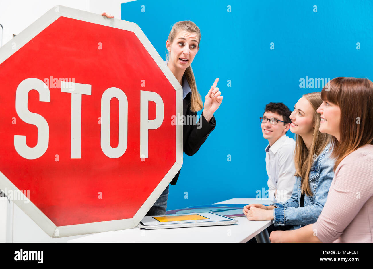 Driving teacher explaining meaning of street signs to class Stock Photo