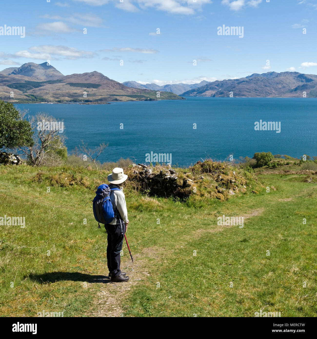 Sightseer at Leitir Fura on the Isle of Skye looking at view across Sound of Skye to the mountains of the Scottish Highlands, West Coast Scotland, UK Stock Photo