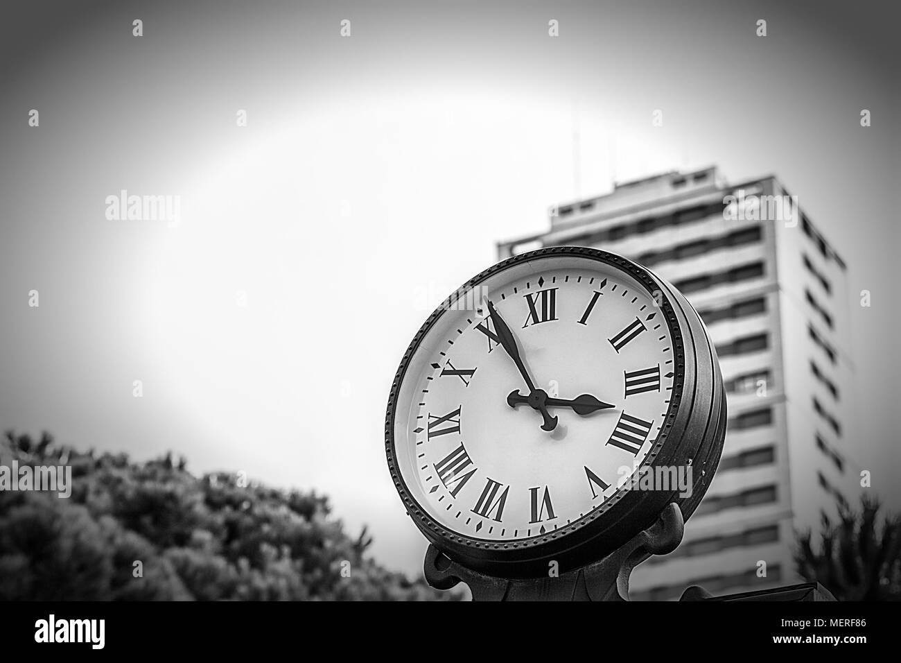 Retro Clock in Town Street with skyscraper on background Stock Photo