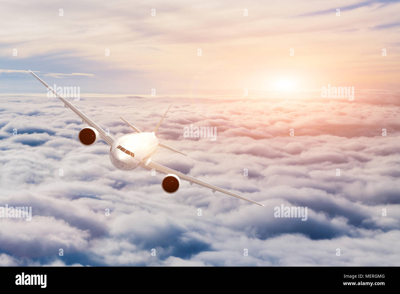 Airplane in cruise flight above the clouds. Beautiful sky, sunset light and reflection on the flying aircraft. Concept about air travel Stock Photo