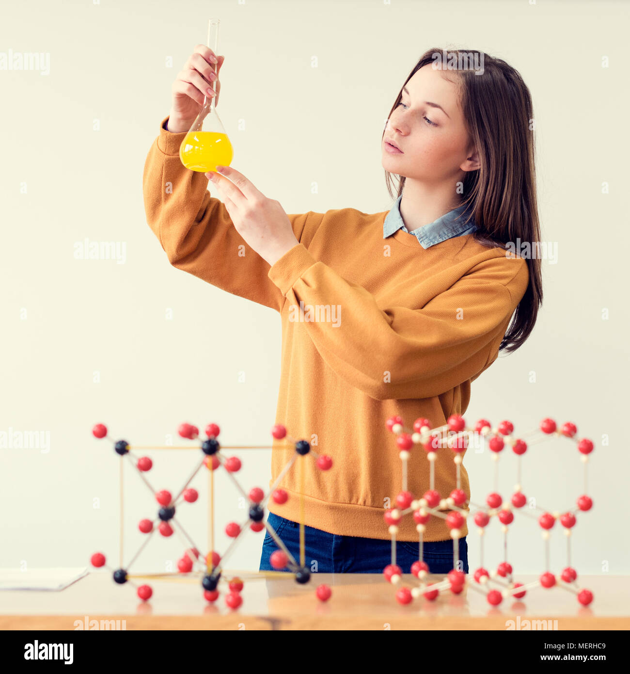 Pretty young caucasian student working in the chemistry lab. College ...