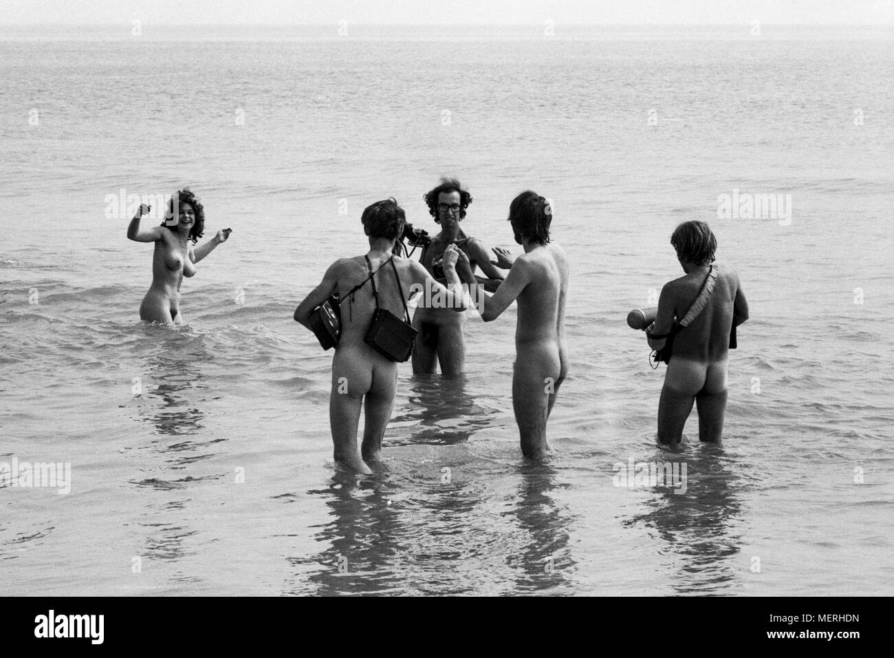 A TV crew at the 1970 Isle of Wight pop festival,  filming hippies skinny dipping in Freshwater Bay for a news report. Hippy guards had ordered all members of the press wanting access to the bay to strip naked themselves before filming or photographing, which the bravest members of the media cheerfully did. Stock Photo