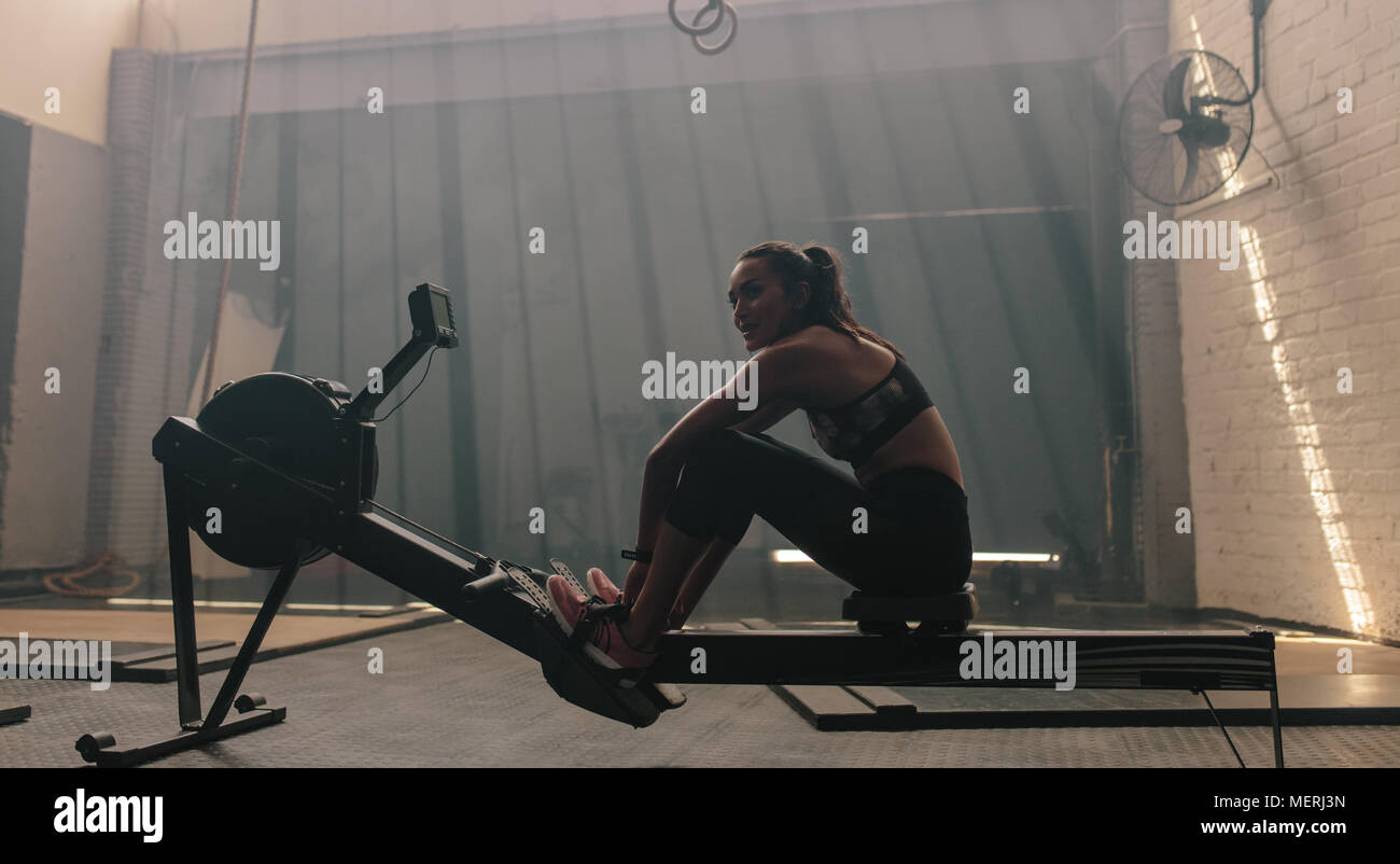 Young woman sitting rowing machine at the gym. Female doing cardio exercise in fitness club Stock Photo Alamy