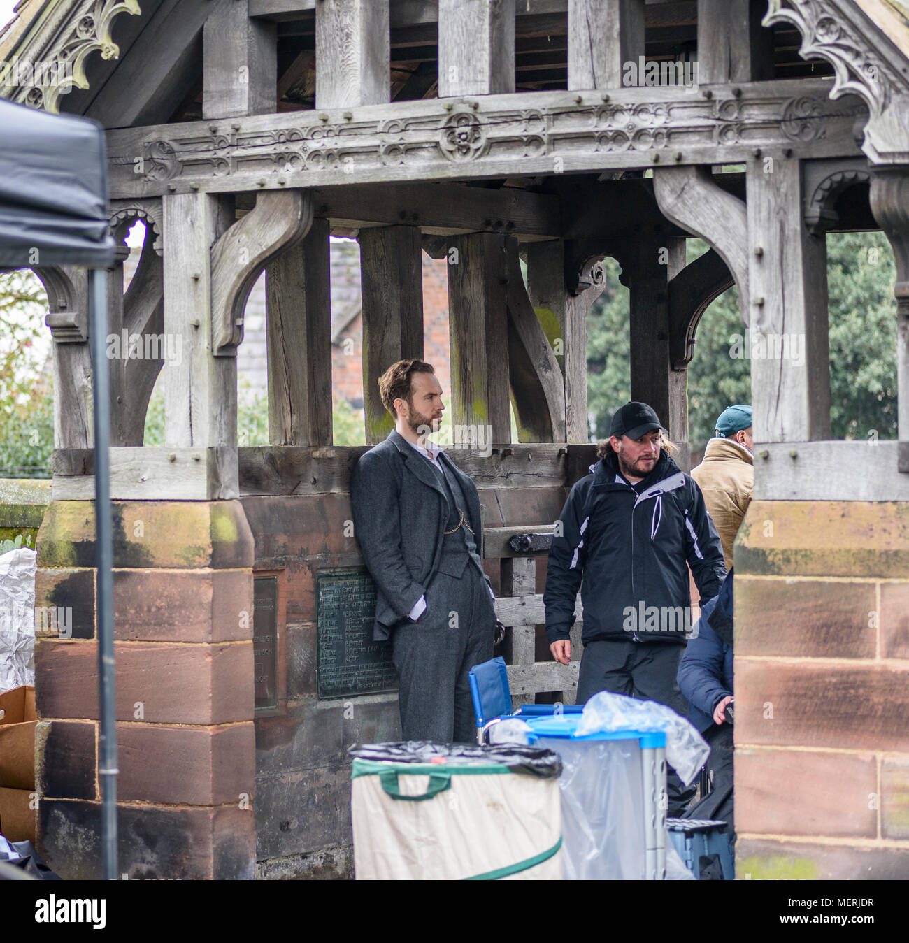 Great Budworth, UK. 11th April, 2018. Actor Rafe Spall with director Craig Viveiros waiting between takes in the church gate in the new BBC drama 'War Stock Photo