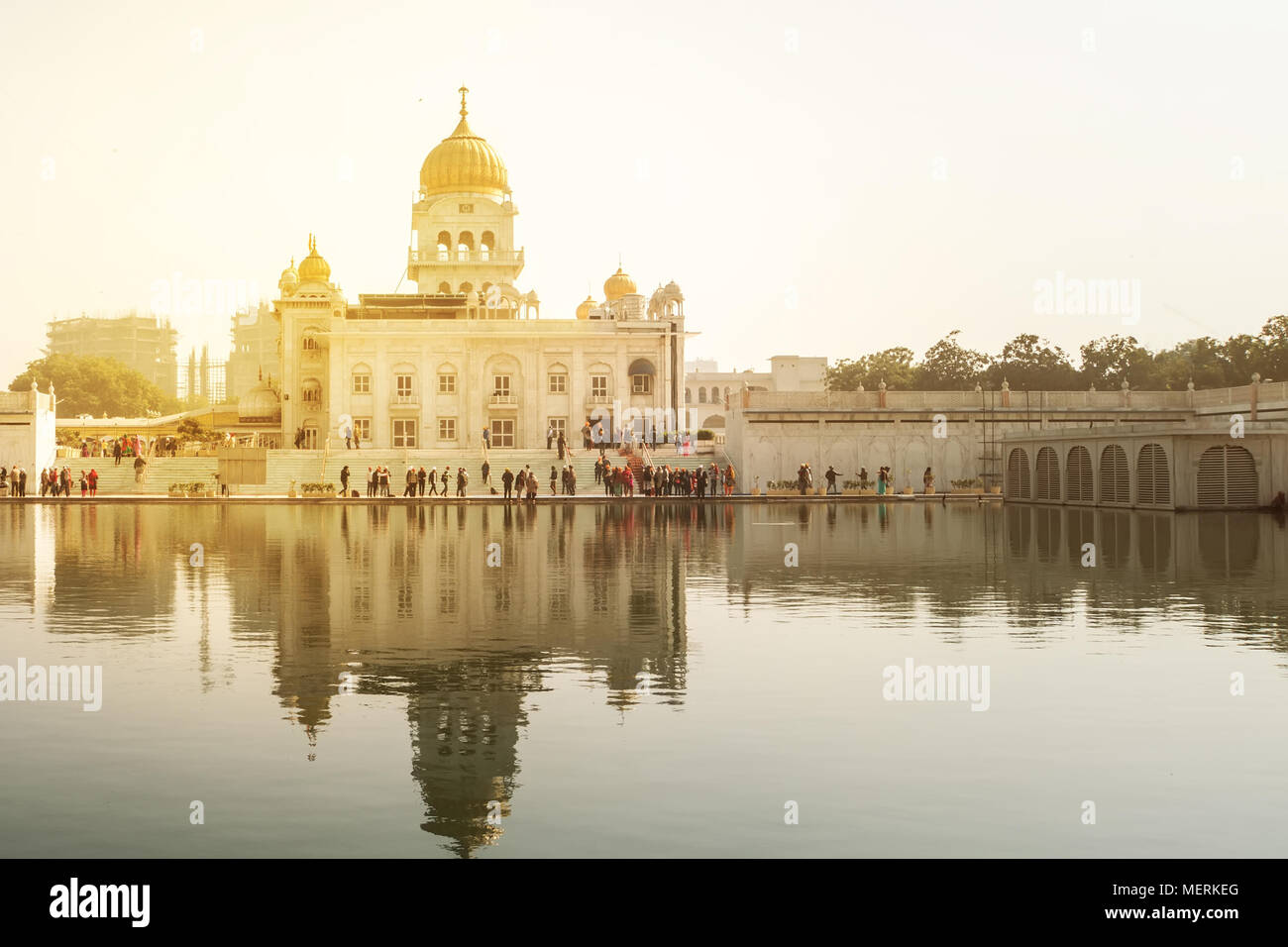 Gurdwara Bangla Sahib is the most prominent Sikh gurdwara. A sacred place of sikhi religion. Golden dome of the temple in the bright yellow sun. A lar Stock Photo
