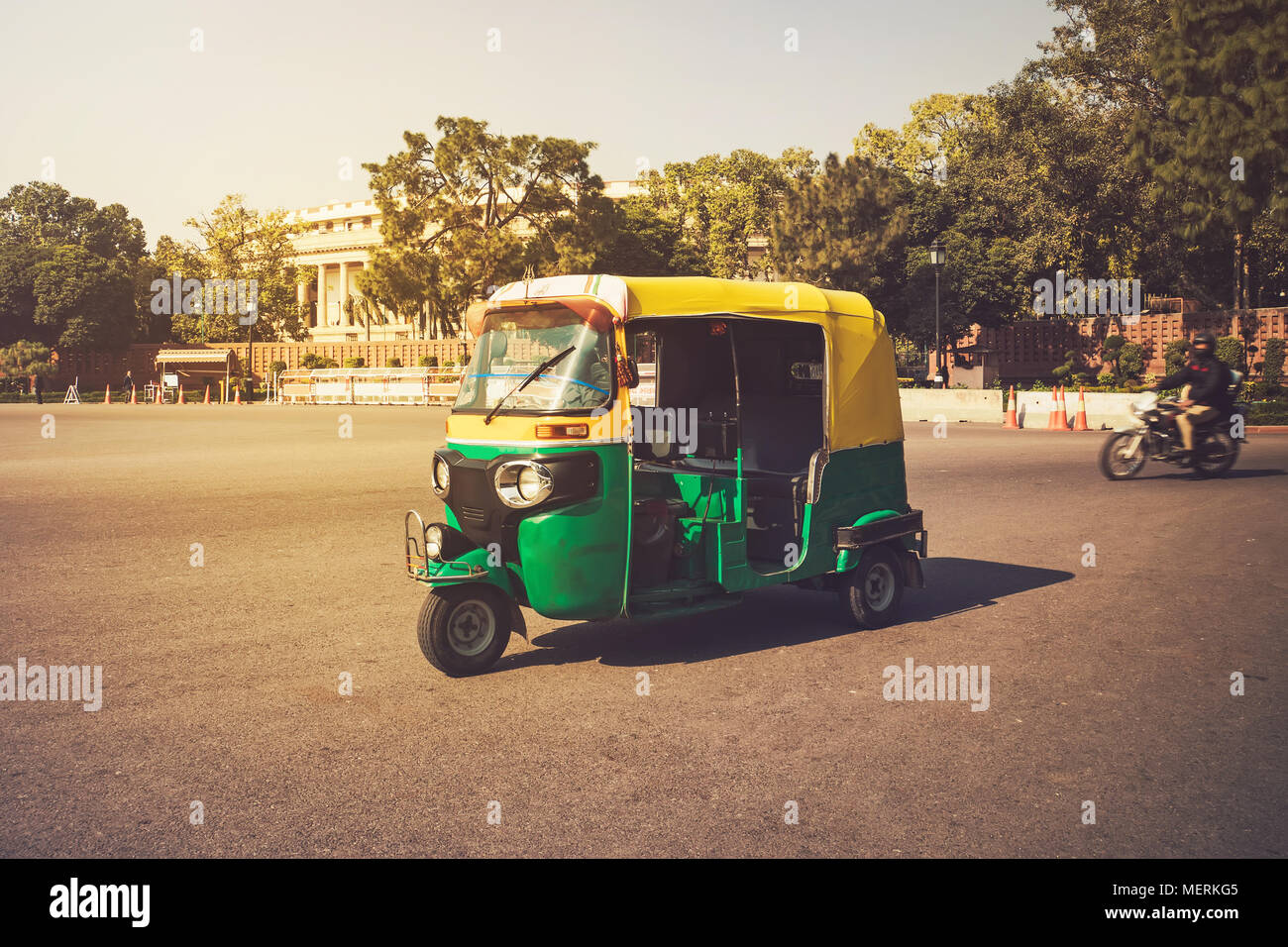 Moto-Rickshaw, New Delhi, India. Indian taxi stands on the street against the backdrop of the presidential Palace. Expensive area of the city. Stock Photo