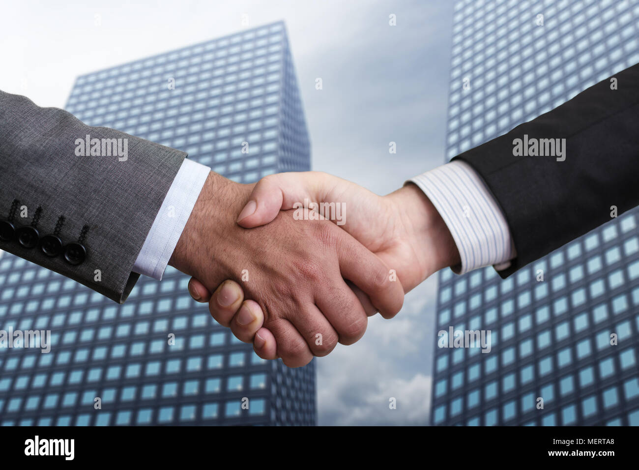 Close-up of business people handshaking on background of modern building. Stock Photo
