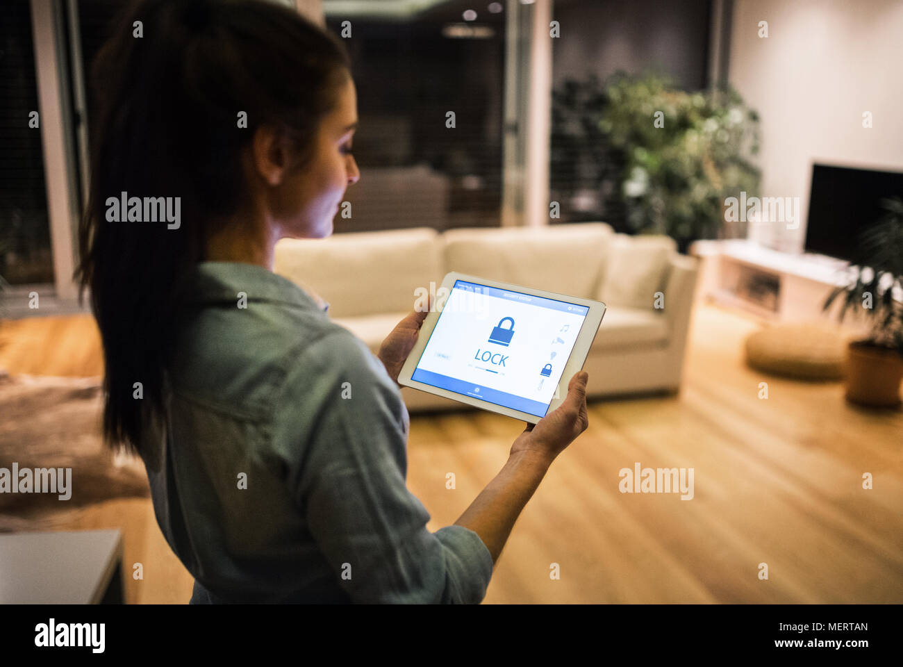 A woman holding a tablet with smart home screen Stock Photo - Alamy