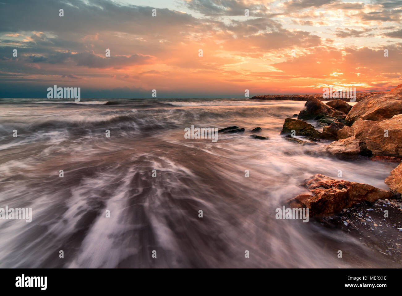 Sunrise over the sea. Stone on the foreground. Stock Photo