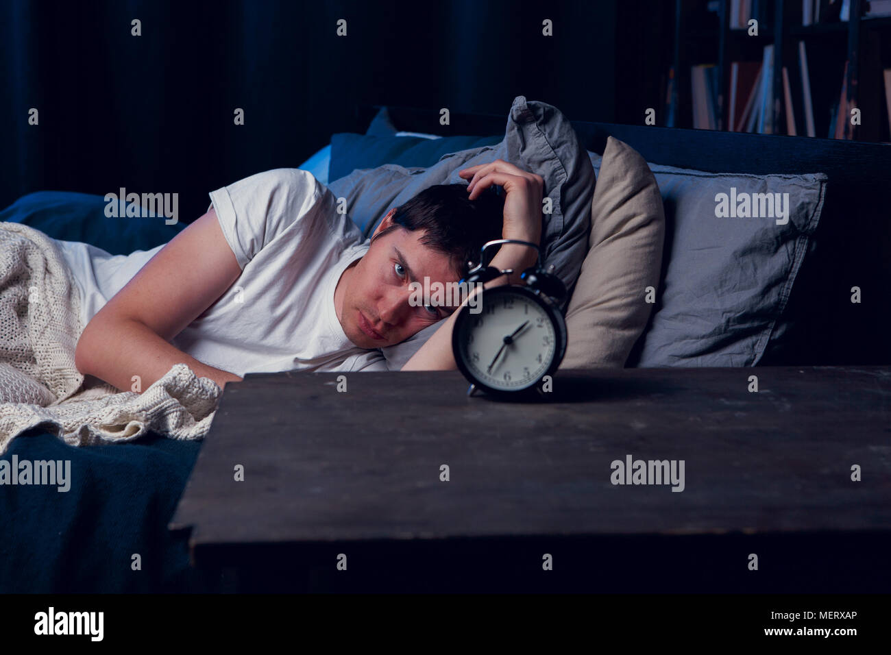 Image of with insomnia lying in bed with alarm clock Stock Photo