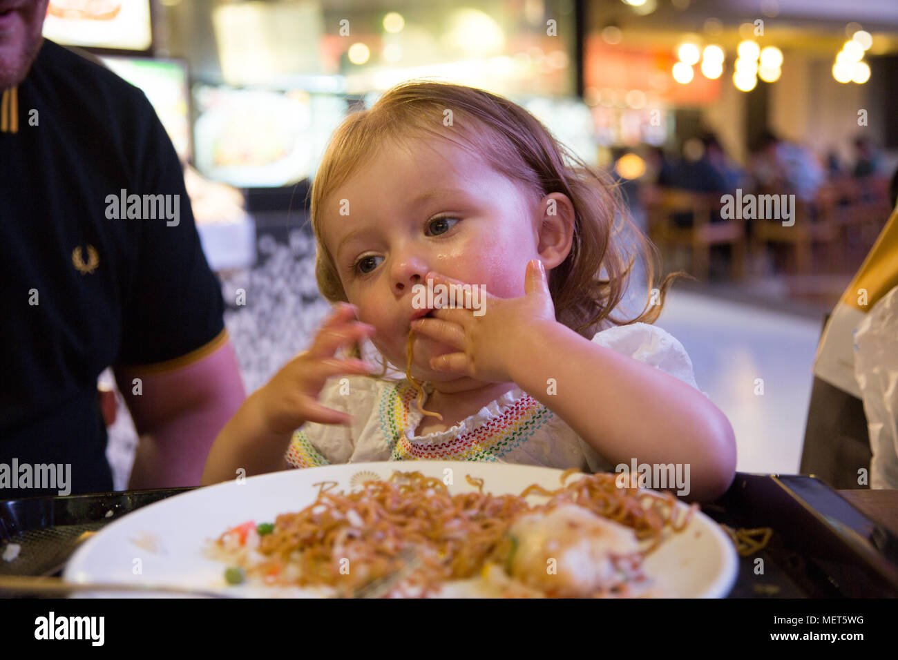 15 month old eating noodles Stock Photo