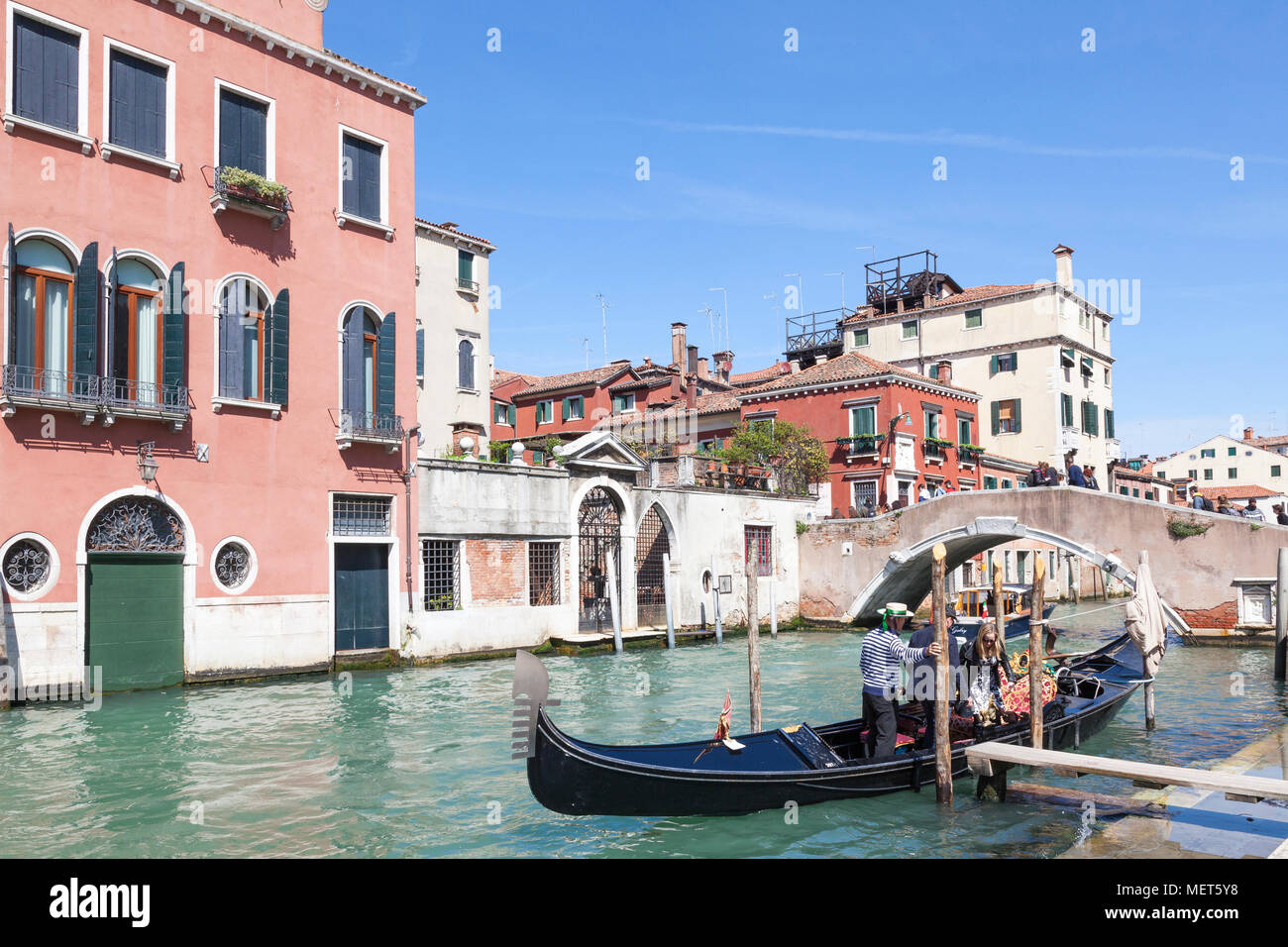Tourists boarding a gondola at Ponte Cavallo on the boudary between the setieres of Castello and  Cannaregio, Venice, Veneto, Italy Stock Photo