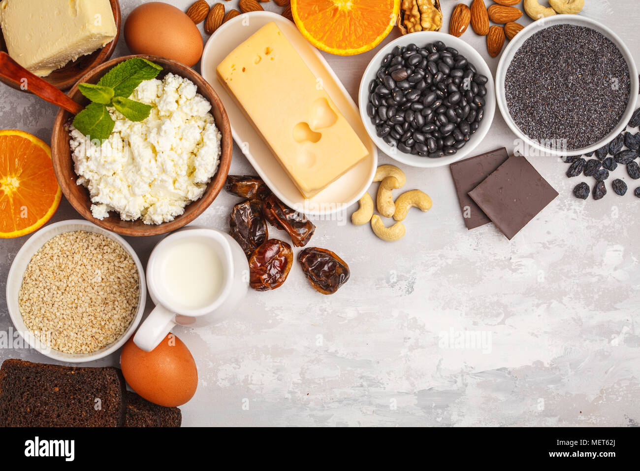 Healthy food nutrition dieting concept. Assortment of high calcium sources. Dairy products, legumes, eggs, nuts, chocolate, poppy, sesame, chocolate. Stock Photo