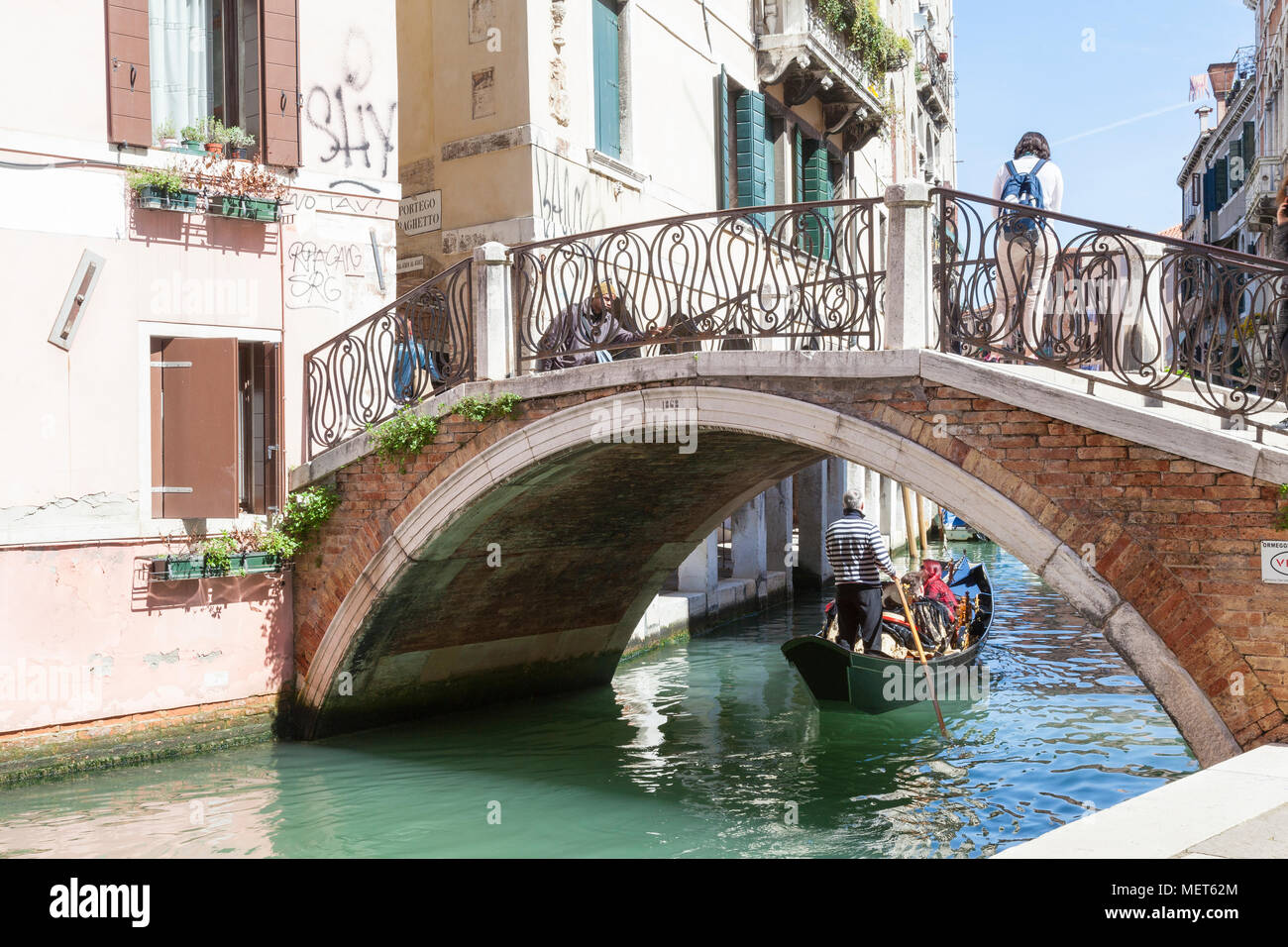 Ponte San Canzian with gondola  and tourists passing below on Rio dei Santi Apostoli, Cannaregio, Venice, Veneto, Italy Stock Photo