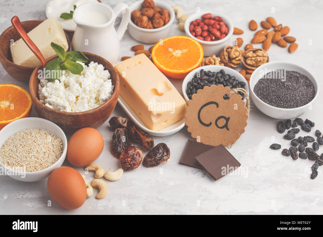 Healthy food nutrition dieting concept. Assortment of high calcium sources. Dairy products, legumes, eggs, nuts, chocolate, poppy, sesame, chocolate. Stock Photo
