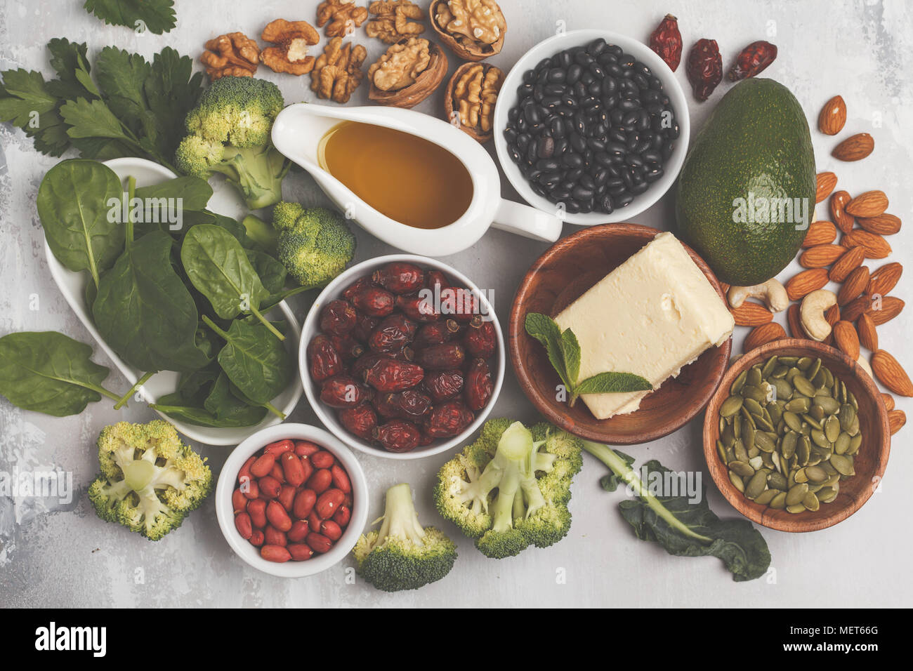 Healthy food nutrition dieting concept. Assortment of high vitamin E sources. Oil, nuts, avocado, butter, healthy fats, rose hips, parsley, seeds Stock Photo