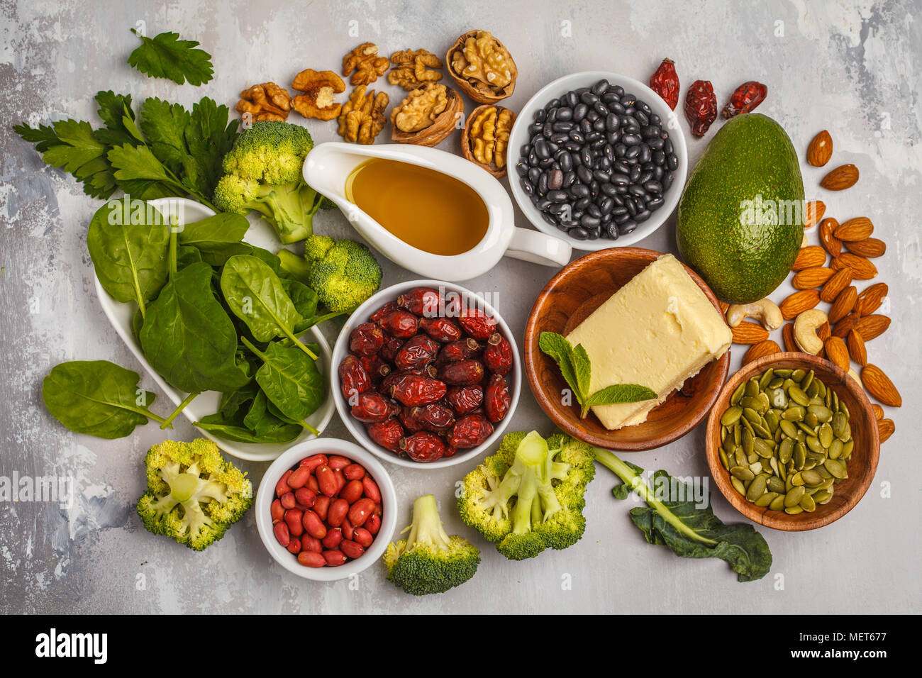 Healthy food nutrition dieting concept. Assortment of high vitamin E sources. Oil, nuts, avocado, butter, healthy fats, rose hips, parsley, seeds Stock Photo