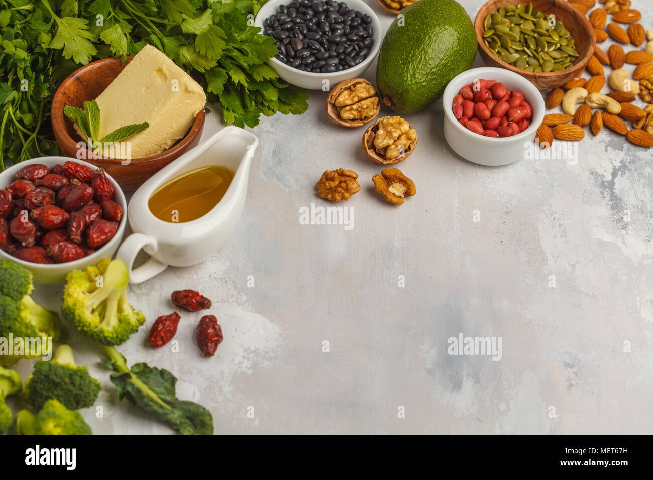 Healthy food nutrition dieting concept. Assortment of high vitamin E sources. Oil, nuts, avocado, butter, healthy fats, rose hips, parsley, seeds Stock Photo