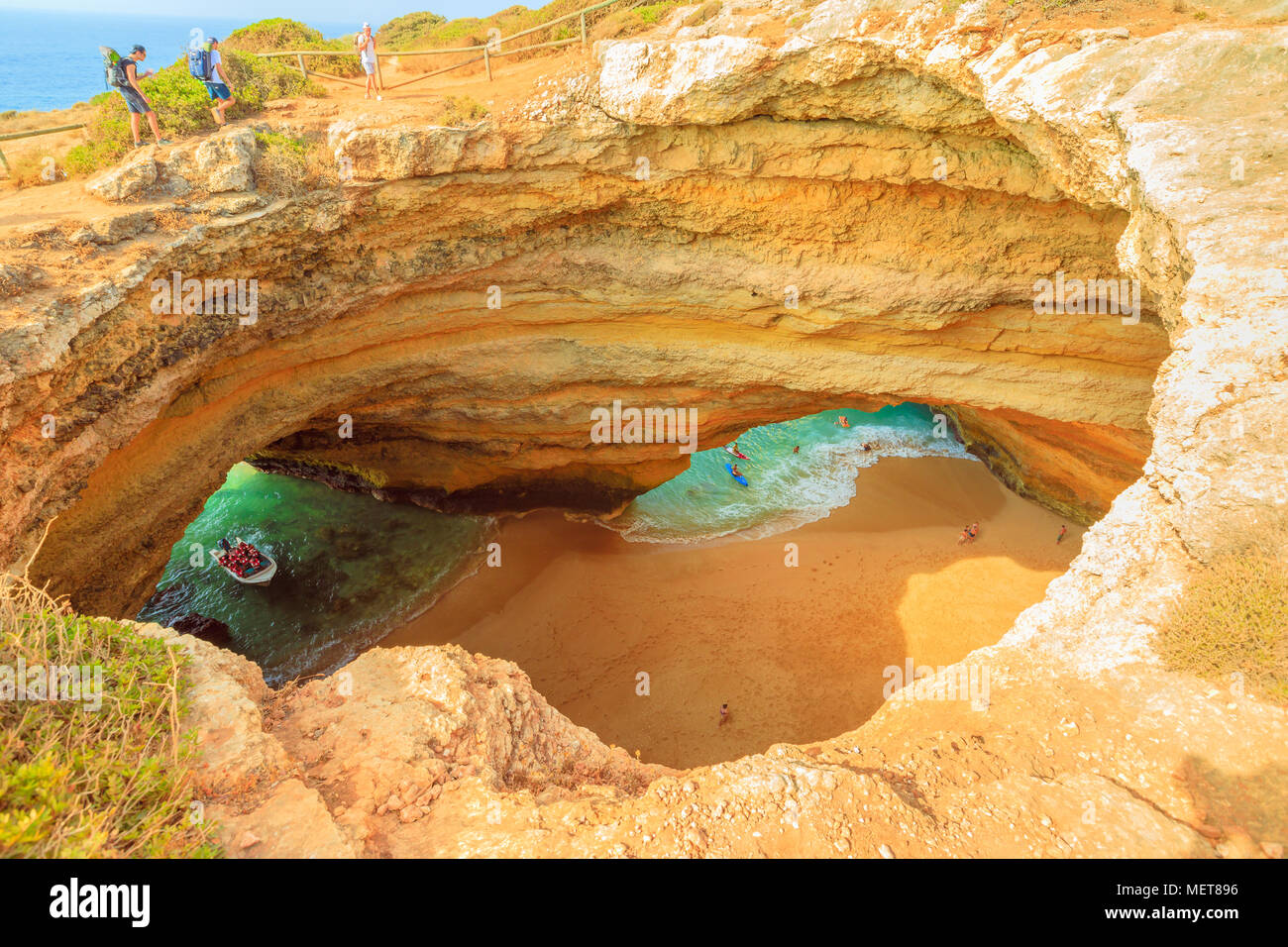 Benagil, Portugal - August 23, 2017: Benagil Cave seen from the top of rocky cliff in Algarve coast. Aerial view of famous sea caves with boat trips leading to visit the caves from Praia de Benagil. Stock Photo