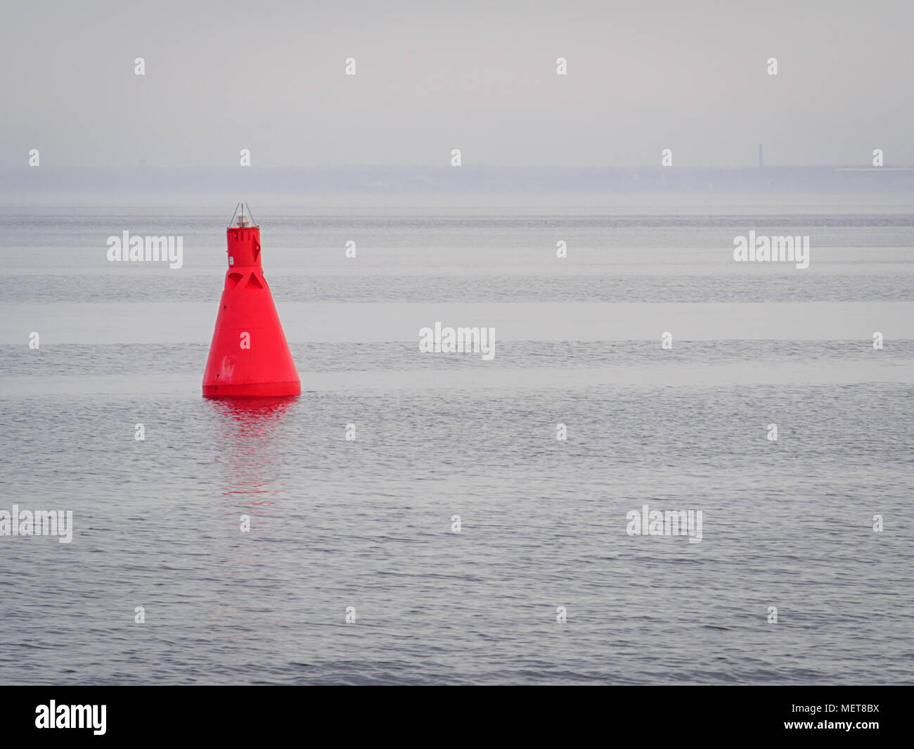 Red buoy as a navigation mark in the calm sea Stock Photo