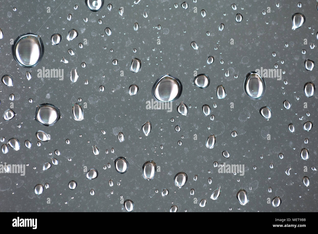 Closeup view of raindrops on a window during rain storm Stock Photo