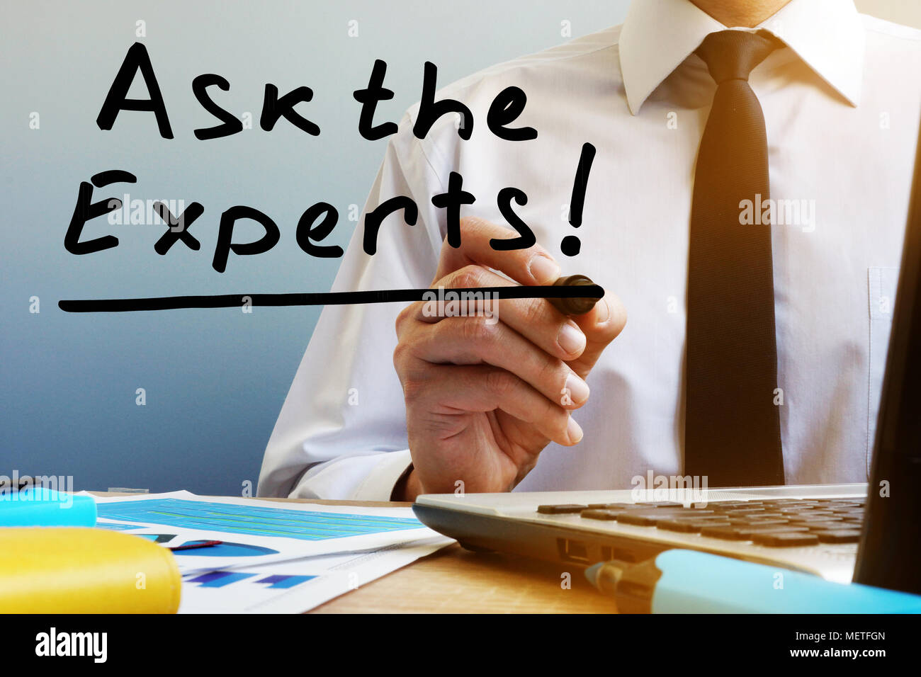 Ask the experts. Man sitting at the table. Stock Photo